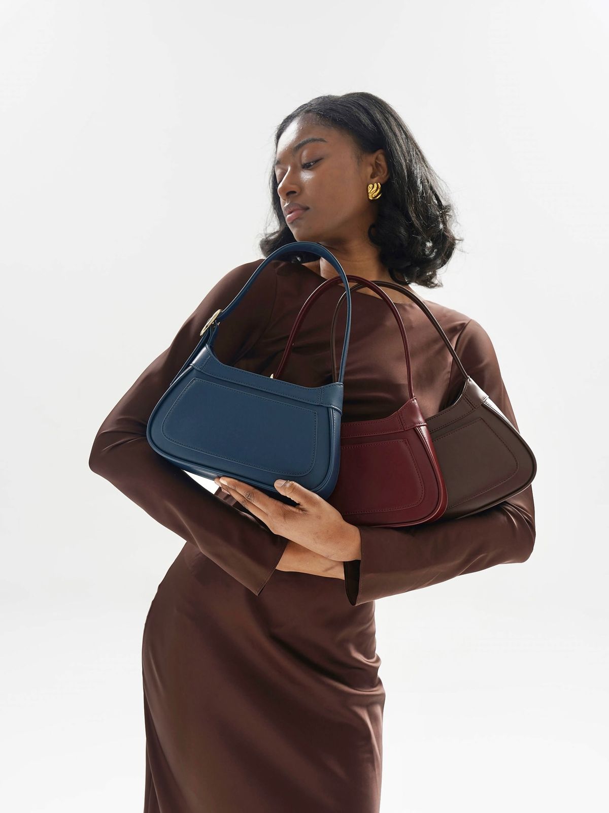 Model holding three LUXBAGZ leather bags